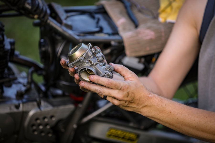Two hands holding a cleaned carburettor