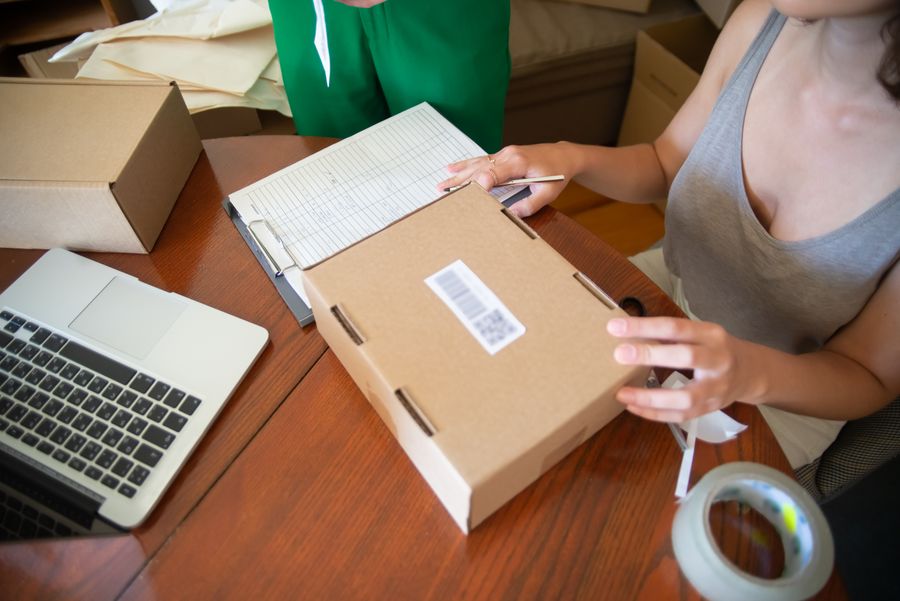 Traitement des commandes sur un ordinateur portable, avec des cartons sur la table