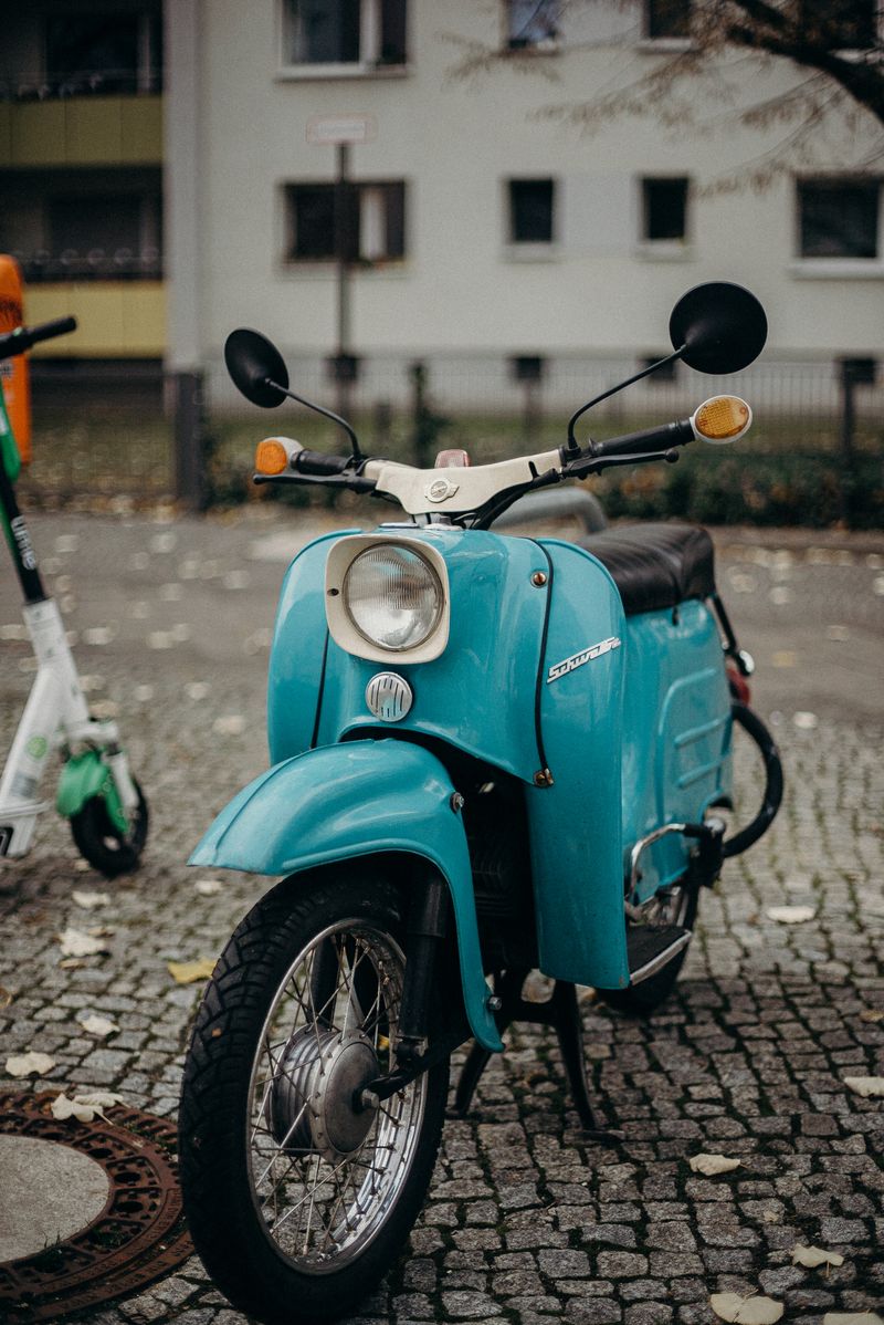 Scooter classique bleu sur des pavés