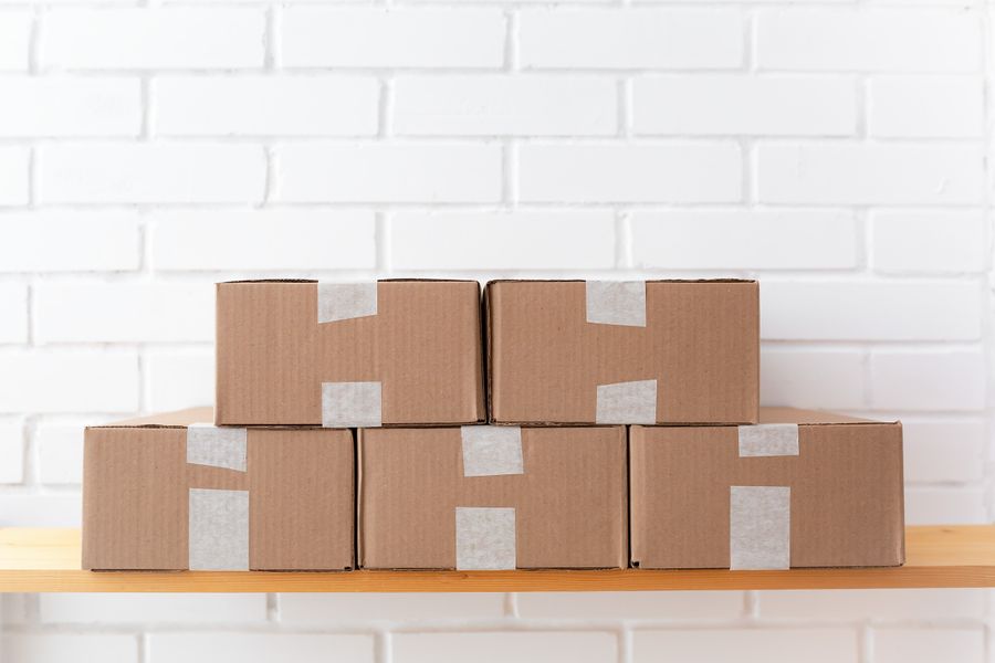Cartons sur une étagère en bois contre un mur blanc